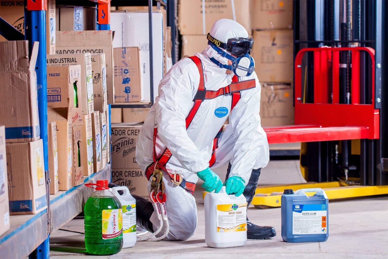 A man in white suit and mask spraying paint.